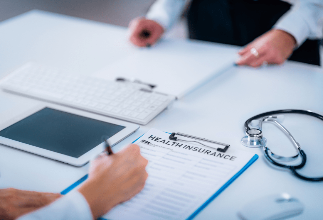 An insurance agent interviewing a client and going through a health checklist whilst utilising data provided by health assessments software for more accurate policy pricing and insurance medical assessments.